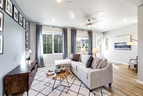 a living room with a couch and a ceiling fan